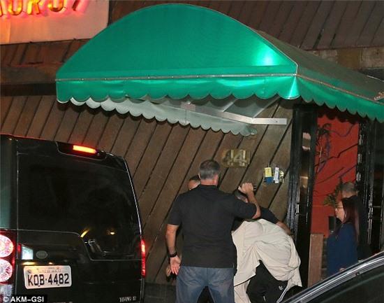 Making a run for it: Justin continues to dive towards his vehicle as he leaves the establishment in Brazil 