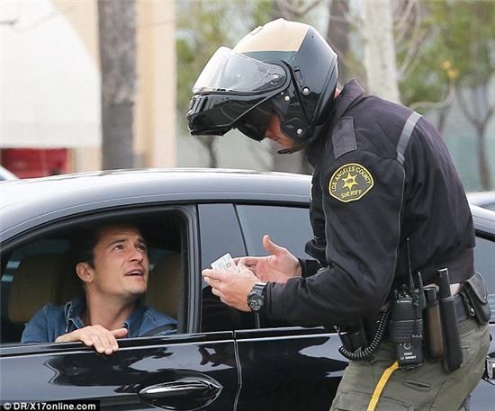 What seems to be the problem, officer?: Orlando Bloom could be seen handing his driving license to a member of the Los Angeles County Sheriff's Department after being stopped for speeding on Thursday