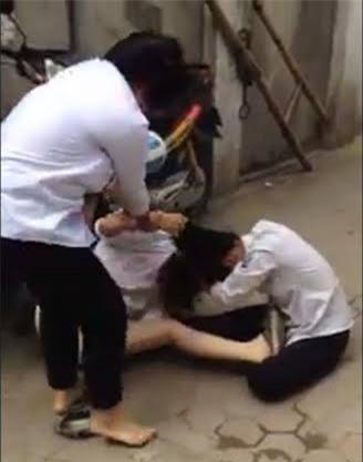  2 nữ sinh sinh giật tóc, đạp vào đầu, vào mặt bạn học (Ảnh cắt từ clip). 