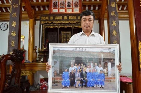  Ông Phan Huy Thanh cùng bức ảnh chụp với ông Ban Ki-moon trước nhà thờ họ Phan Huy 