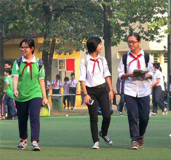 Bức ảnh bé Kiến (giữa) đeo khăn đỏ đi lại giữa sân trường