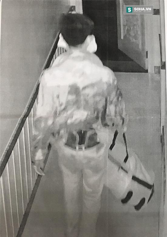 Nghi phạm cầm chiếc túi (tang vật vụ án) rời khỏi hiện trường