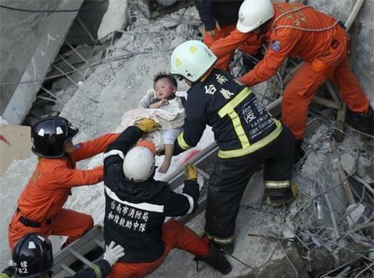  Một em bé được cứu sống khỏi đống đổ nát của tòa nhà 17 tầng ở TP Đài Nam hôm 6-2. Ảnh: Reuters 