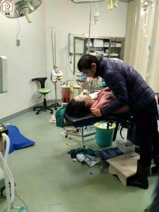 Người chồng đau khổ đứng cạnh thi thể vợ.