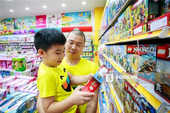  2 bố con tranh thủ rẽ vào một cửa hàng đồ chơi và mua một bộ lego. 