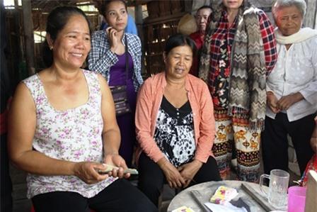 Bà Hường (trái) bán vé số cạnh cây chuối khủng của mình.