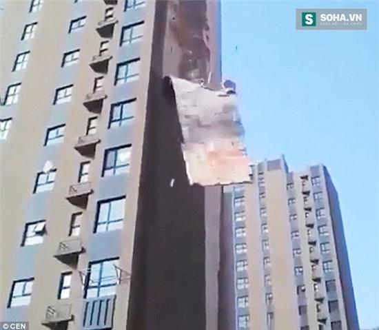 Từng mảng vữa khổng lồ của tòa nhà cao tầng rơi xuống trước sự kinh ngạc của người dân xung quanh.