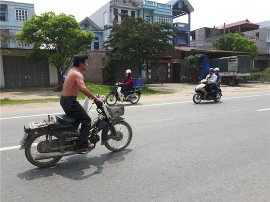 Người đàn ông đi xe máy trong tư thế này suốt quãng đường 5km khiến nhiều người đi đường bị phen hú vía (ảnh cắt từ clip)