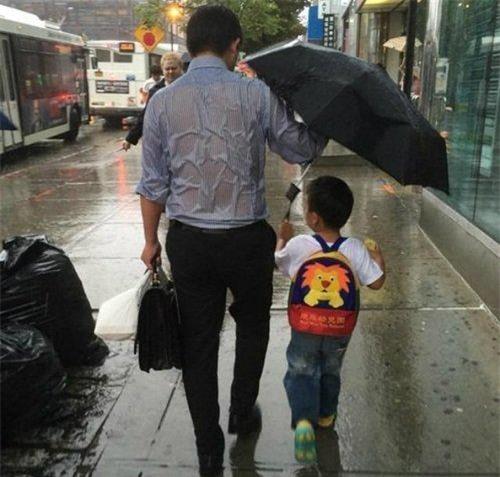  Ông bố để mặc thân mình ướt sũng, nhường toàn bộ chiếc ô cho con trai 