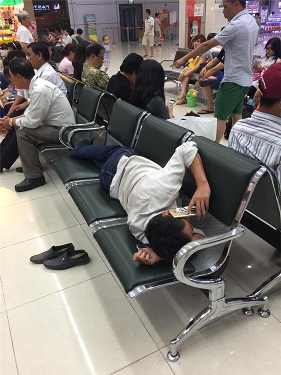 Hình ảnh phát ngượng ở sân bay Nội Bài: Người đàn ông nằm dài ra ghế nấu cháo điện thoại - Ảnh 2.
