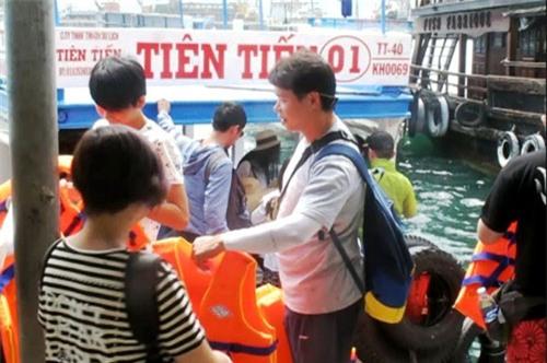  Một hướng dẫn viên du lịch người Trung Quốc hướng dẫn khách tại cảng Cầu Đá (Nha Trang) vào sáng 29-6 Ảnh: Hồng Ánh 