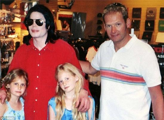 Jackson poses for a photo in 2004 with friend Mark Lester and Lester's two children Harriet and Olivia