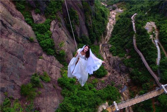 Newlyweds take wedding photos hanging from bridge, Yueyang, Hunan province, China - 09 Aug 2016