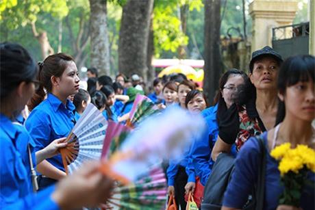 Thay phiên nhau quạt mát cho dòng người xếp hàng