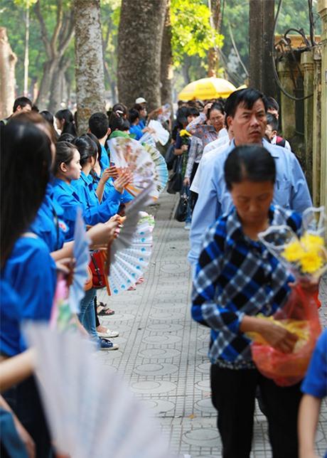 Thay phiên nhau quạt mát cho dòng người xếp hàng