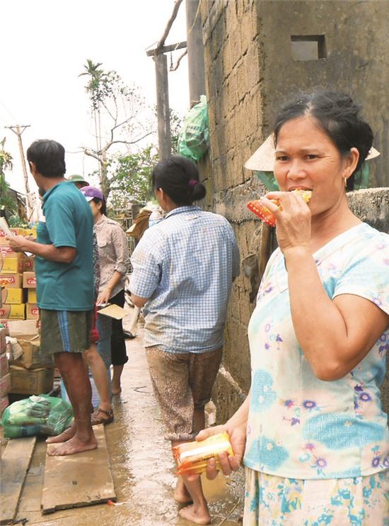 Người dân xã Quảng Sơn, huyện Quảng Trạch, Quảng Bình 
ăn vội miếng lương khô vừa được cứu trợ.
