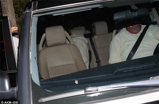 Disappearing act: Justin is seen under a bedsheet as he gets into an awaiting SUV 
