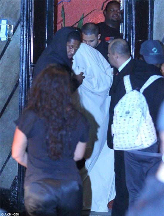 We can see you! Justin Bieber leaves the popular brothel Centauros in Rio de Janeiro covered by a cream bedsheet and surrounded by minders