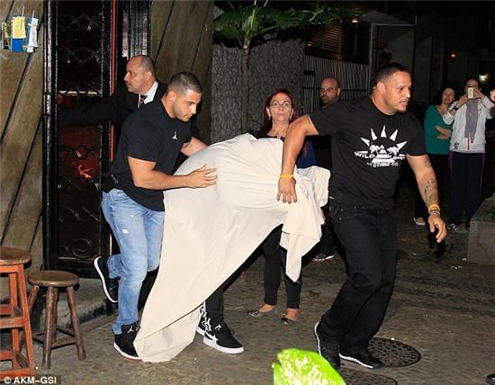 Now you see him: Justin Bieber exits a Brazilian brothel where fans had already gathered to catch a glimpse of the star 