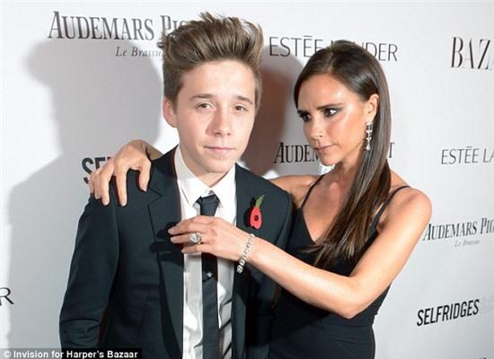 Handsome date: Victoria Beckham was accompanied by her teenage son Brooklyn, 14, as she attended the 2013 Harper's Bazaar Women of the Year Awards at London's Claridge's Hotel on Tuesday evening