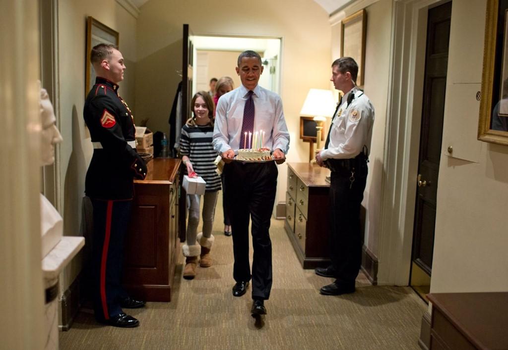 Ông Obama cùng con gái của Chánh Văn phòng Denis McDonough mang chiếc bánh kem để tổ chức sinh nhật bất ngờ cho ông này tại văn phòng cánh Tây Nhà Trắng. Ảnh: White House.