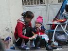 Mẹ cùng con nhỏ đánh giày trên phố Hà Nội khiến bao người xúc động