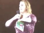 Đang biểu diễn thì mưa, Adele kẹp mic vào... ngực để mặc áo fan đưa
