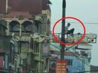 Nam thanh niên ở Hà Nội ngồi vắt vẻo trên cột điện