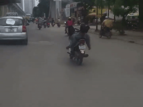 Thanh niên nằm ngửa, lái xe máy bằng chân như làm xiếc trên phố