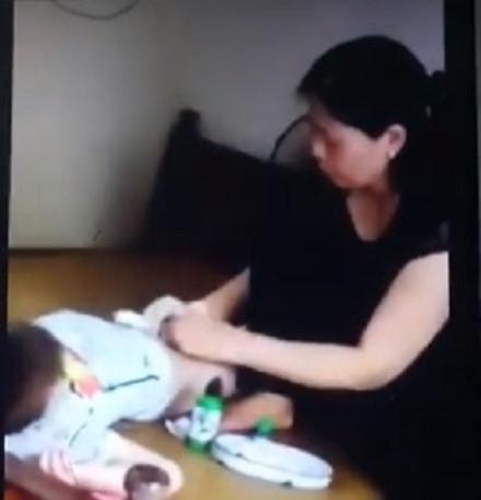 Bà Hiền "tay không" thực hiện nong tách bao quy đầu cho một bé trai. Ảnh cắt từ clip.