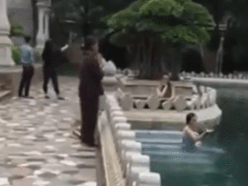 Cô gái trẻ hồn nhiên tắm giữa hồ nước trong chùa