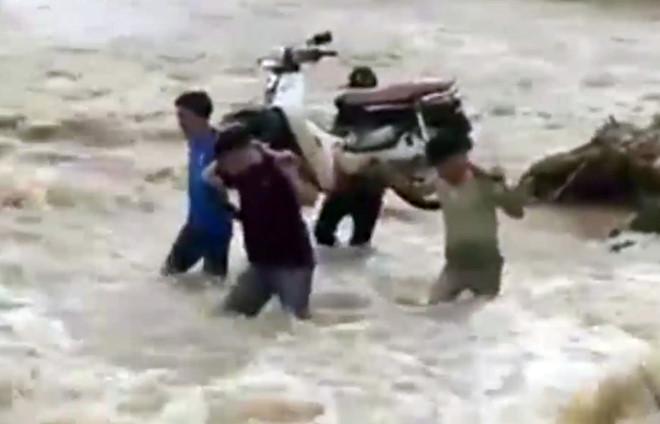 Thầy giáo khiêng xe máy băng qua nước lũ đến trường-1