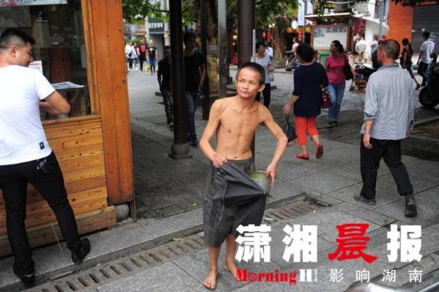 Người ăn mày khuyết tật tận tuỵ che ô cho cụ già chống nạng bước đi trong mưa gây xúc động-2