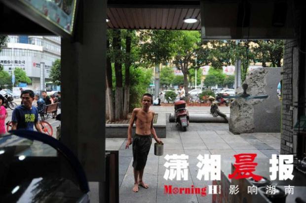 Người ăn mày khuyết tật tận tuỵ che ô cho cụ già chống nạng bước đi trong mưa gây xúc động-4