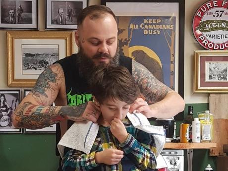 Nằm lăn ra đất để cắt tóc cho cậu bé, hành động này của người thợ đã được cả thế giới tung hô-1