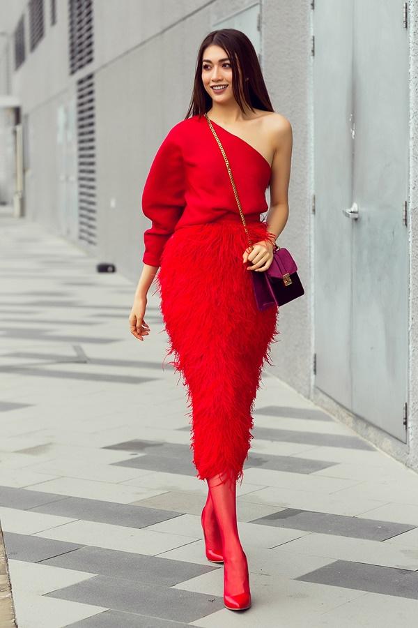 Chiếc áo với cấu trúc lệch vai đi kèm chân váy bút chì đính lông vừa thanh lịch, vừa gợi cảm.