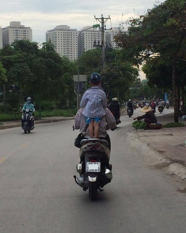 Bà mẹ 1 tay lái xe máy, 1 tay ôm con bú trên đường-3