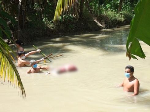 Người phụ nữ bị trói hai chân, dìm dưới mương nước bởi 5 thanh tre