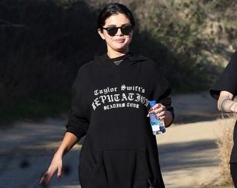 Selena Gomez mặc áo hoodie màu đen có in tên Taylor Swift và tour diễn 