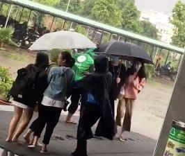 Ấm lòng hình ảnh bác bảo vệ mặc áo mưa, che ô cho sinh viên-1