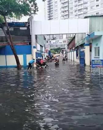 Bác bảo vệ ướt sũng vẫn đẩy xe qua chỗ ngập cho sinh viên-1