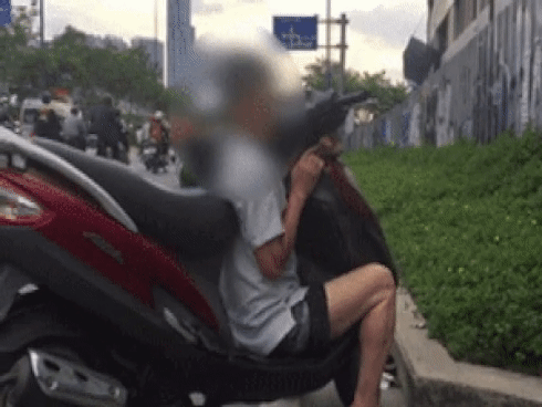 Clip: Người đàn ông ngồi rung đùi, ôm xe máy như ‘ôm người tình’ trên xa lộ Hà Nội