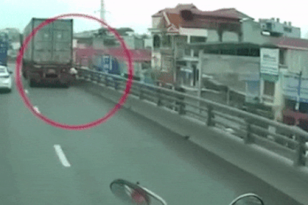 Clip: Hú hồn nhìn xe máy đi vào đường cấm bị xe container ép vào thành cầu suýt chết