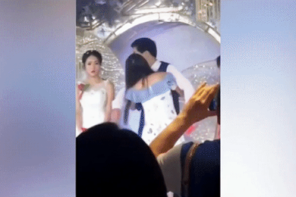 Xôn xao clip người yêu cũ lên sân khấu ôm hôn chú rể nhưng phản ứng của cô dâu mới khó hiểu