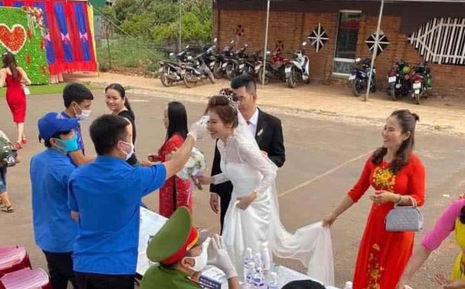 Đám cưới mùa dịch: Cô dâu chú rể cùng họ hàng 2 bên xếp hàng chờ đo thân nhiệt trước khi vào hôn trường-1