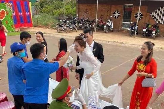 Đám cưới mùa dịch: Cô dâu chú rể cùng họ hàng 2 bên xếp hàng chờ đo thân nhiệt trước khi vào hôn trường
