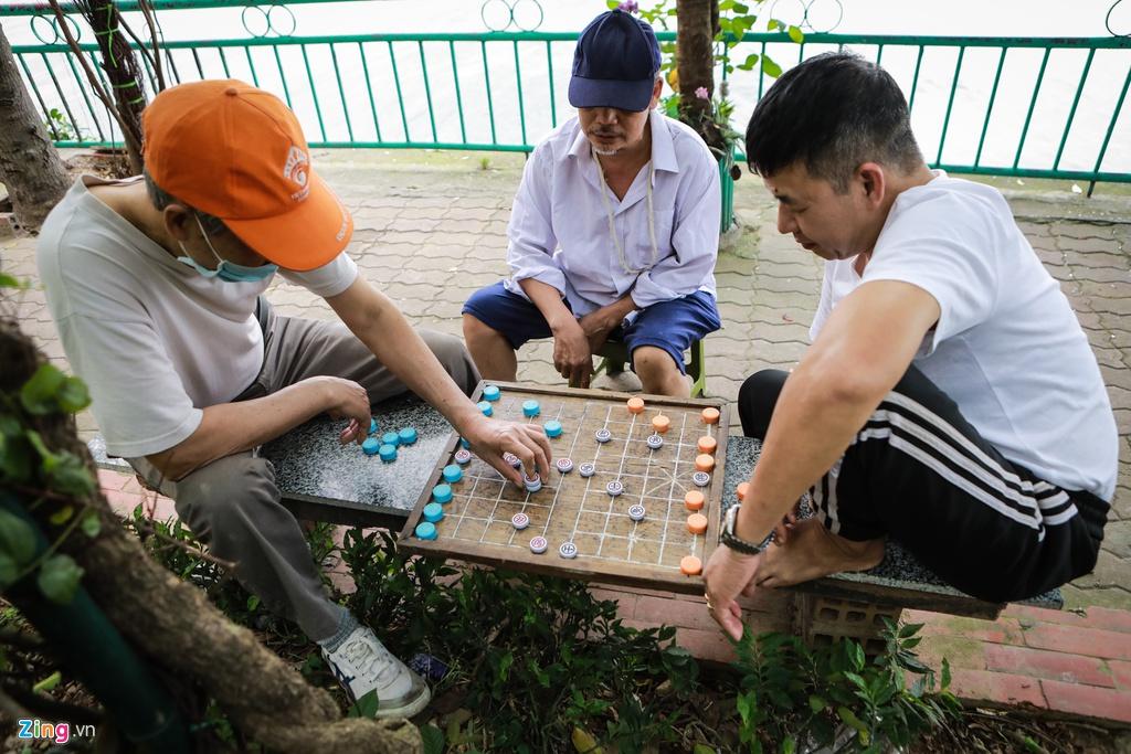 Sinh hoạt của người dân quanh hồ Tây vẫn diễn ra bình thường. Các cụ già vẫn giữ thói quen chơi cờ cùng nhau.