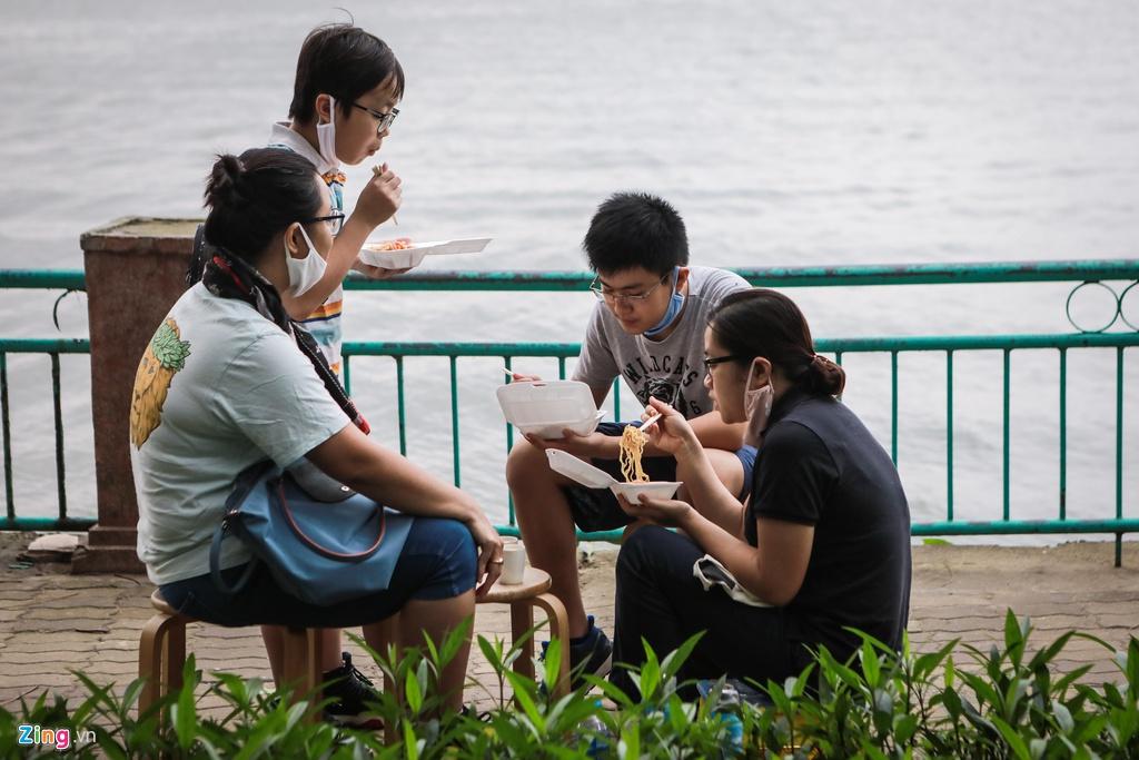 Lãnh đạo Hà Nội yêu cầu tất cả cơ sở kinh doanh dịch vụ phải đóng cửa trong 2 tuần, đến ngày 5/4, trừ các cửa hàng thiết yếu như xăng dầu, thuốc, cửa hàng bán thức ăn. Hàng quán đóng cửa, một số gia đình mua đồ ăn ra khu vực hồ Tây ngồi dùng.