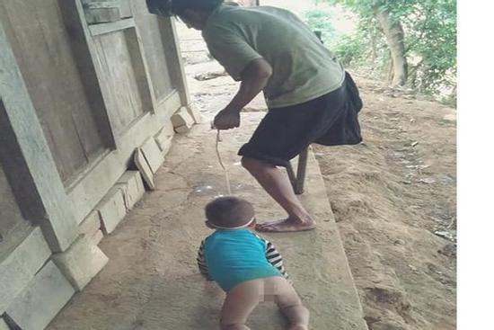 Sự thật bức ảnh ông tàn tật buộc dây dắt cháu cởi truồng bò lổm ngổm dưới nền đất