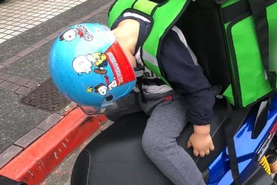 Em bé ngủ gật trên xe khi cùng bố đi ship hàng khiến dân mạng xúc động